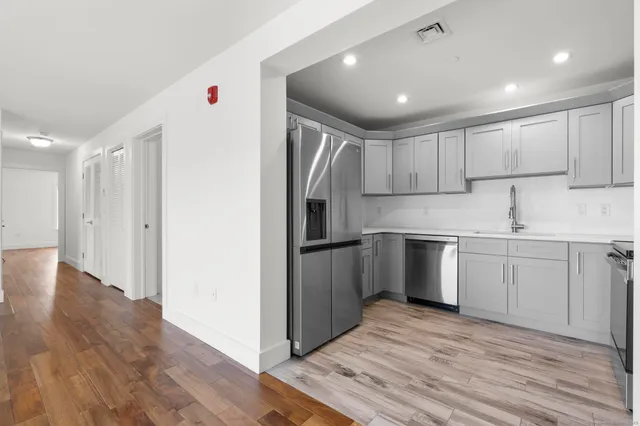 a kitchen with white cabinets and stainless steel appliances
