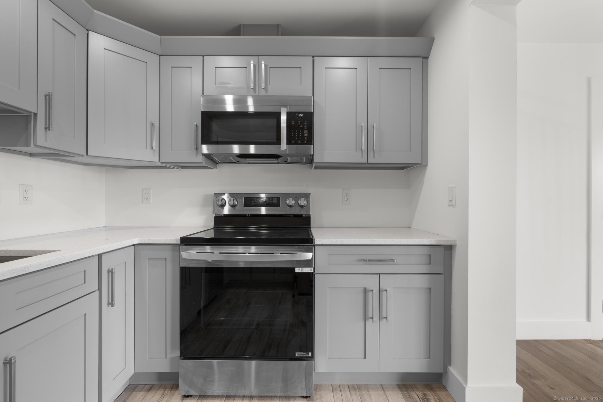 245 East Main Street, Unit 2 Branford, CT 06405 - Photo 24 of 40 a kitchen with white cabinets and stainless steel appliances