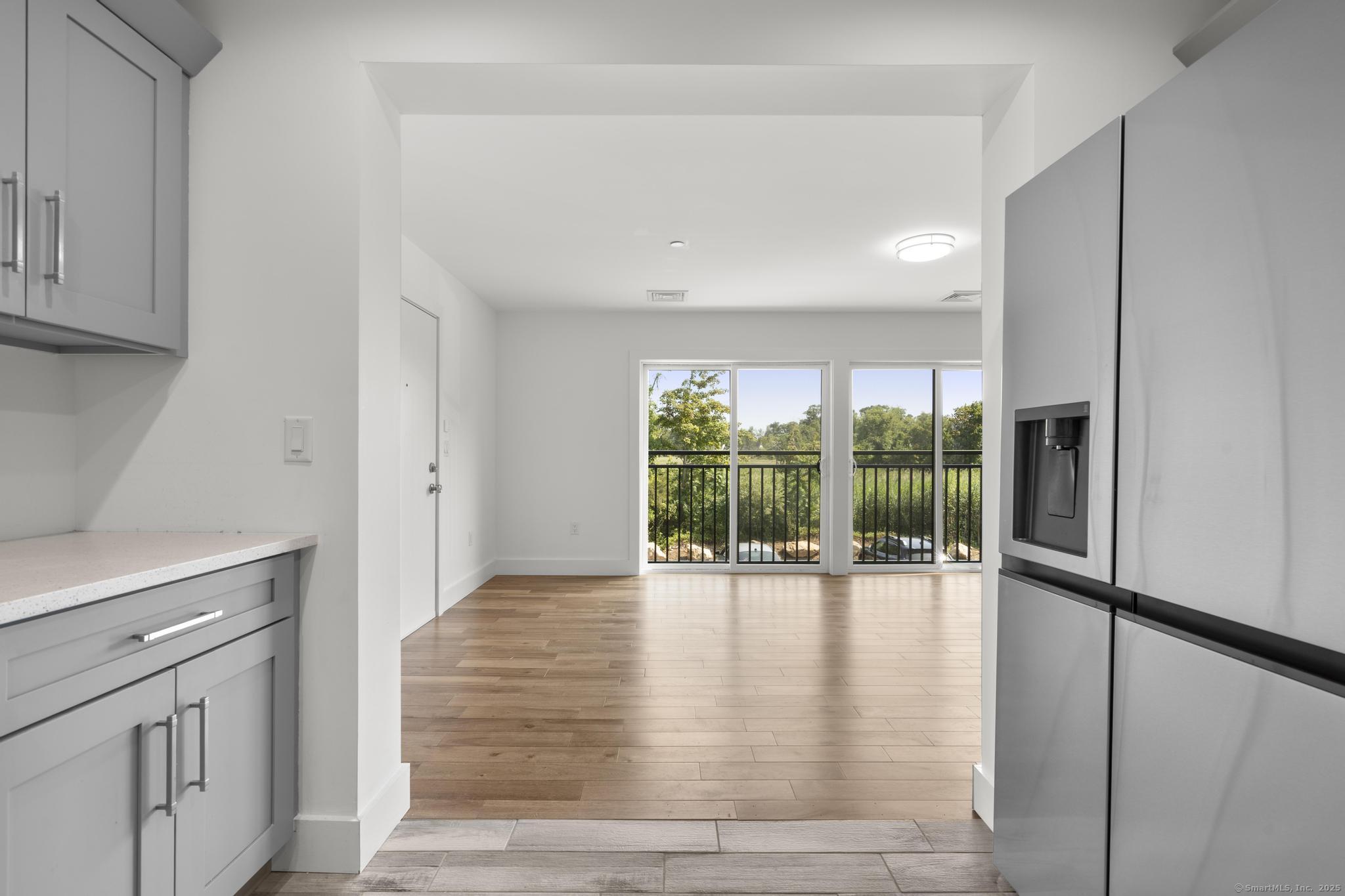 245 East Main Street, Unit 2 Branford, CT 06405 - Photo 25 of 40 a view of an empty room with wooden floor and a sliding door