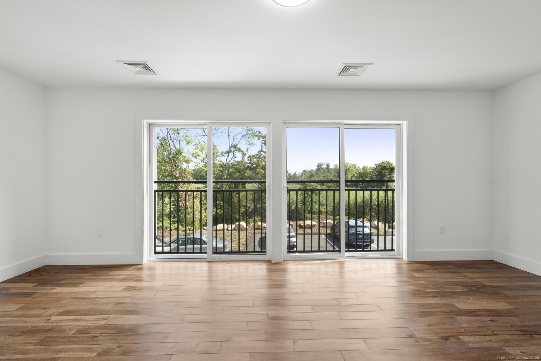 245 East Main Street, Unit 2 Branford, CT 06405 - Photo 27 of 40 a view of an empty room with wooden floor and a window