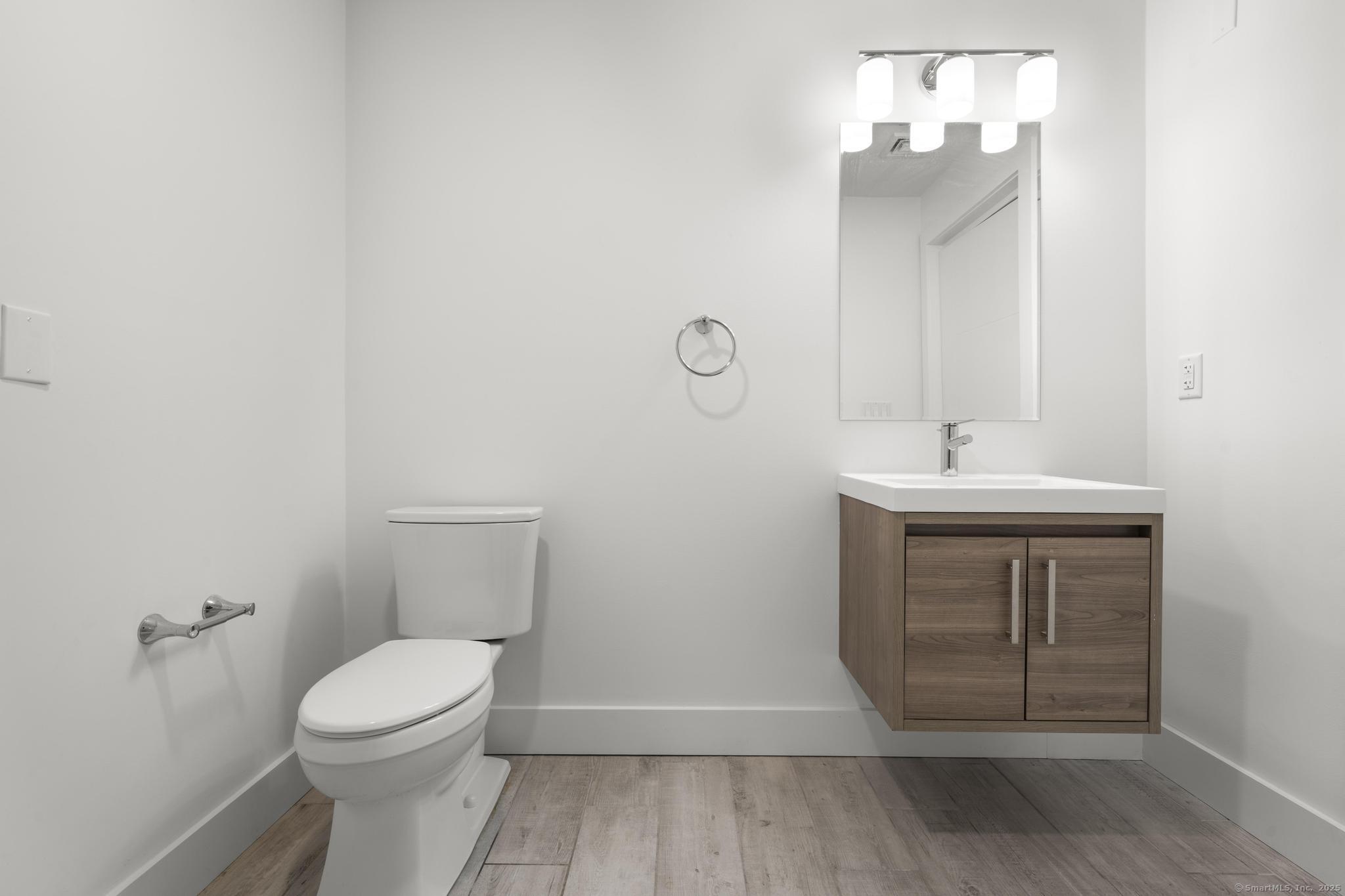 245 East Main Street, Unit 2 Branford, CT 06405 - Photo 28 of 40 a bathroom with a sink a toilet and mirror