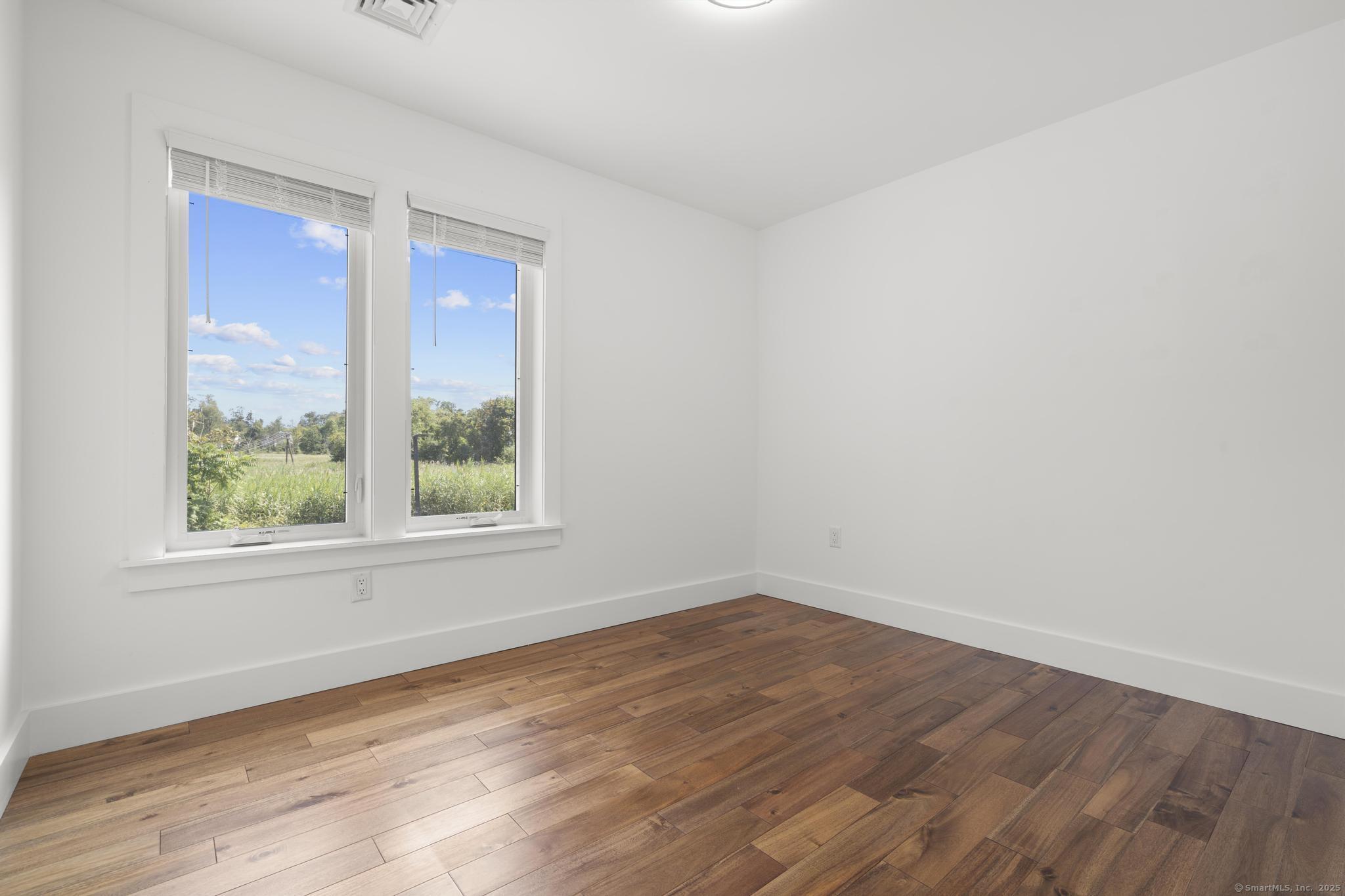 245 East Main Street, Unit 2 Branford, CT 06405 - Photo 33 of 40 an empty room with wooden floor and windows