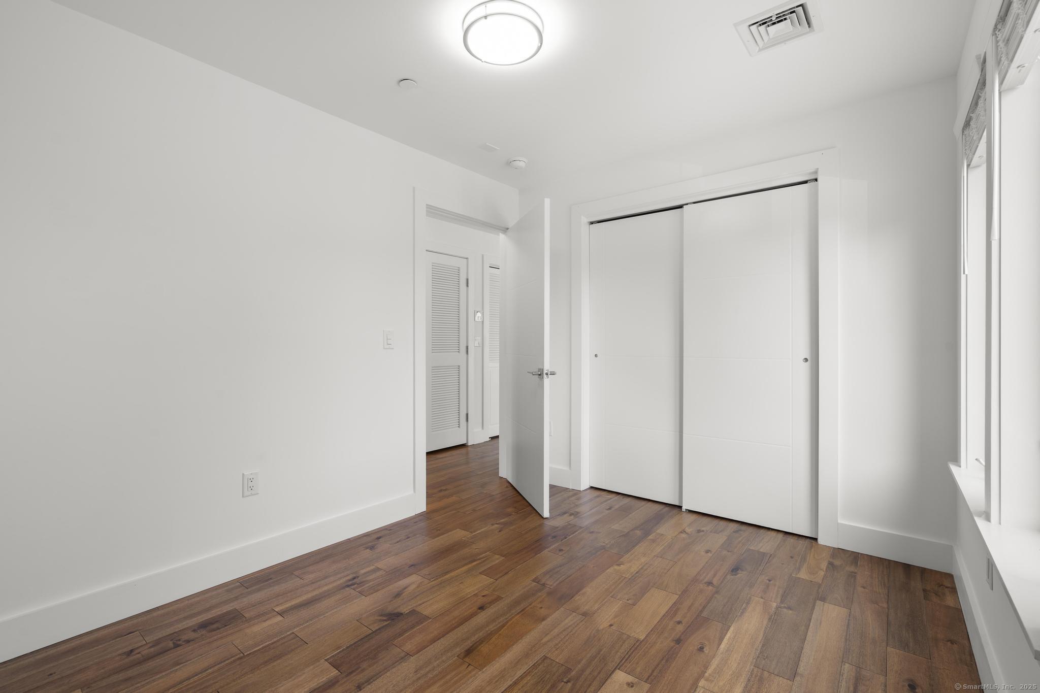 245 East Main Street, Unit 2 Branford, CT 06405 - Photo 34 of 40 a view of an empty room with wooden floor and a window