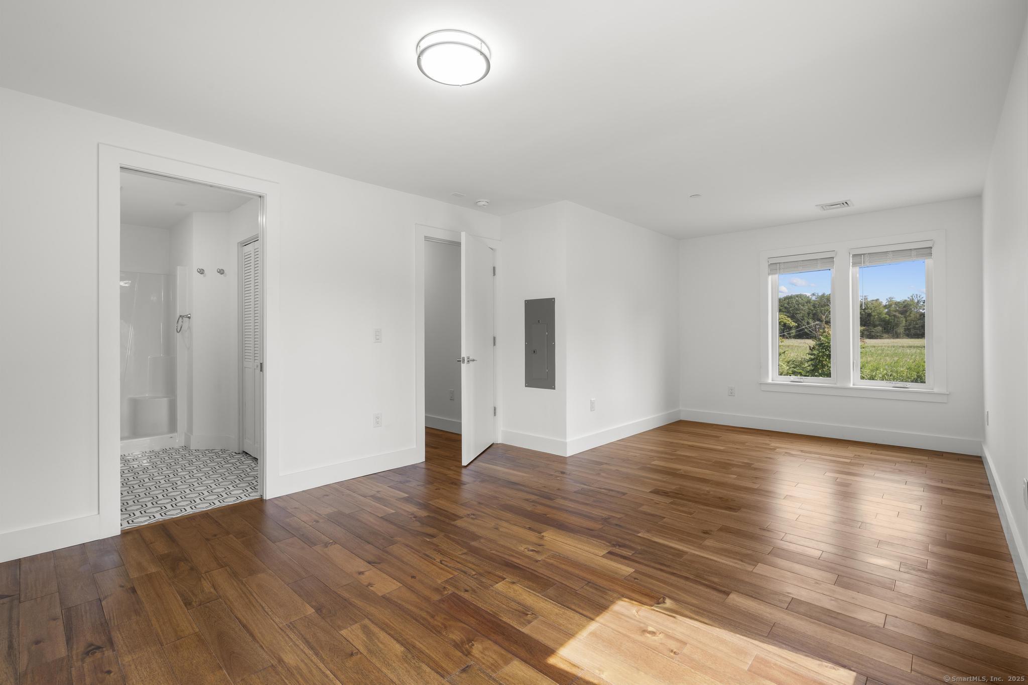 245 East Main Street, Unit 2 Branford, CT 06405 - Photo 36 of 40 an empty room with wooden floor and windows