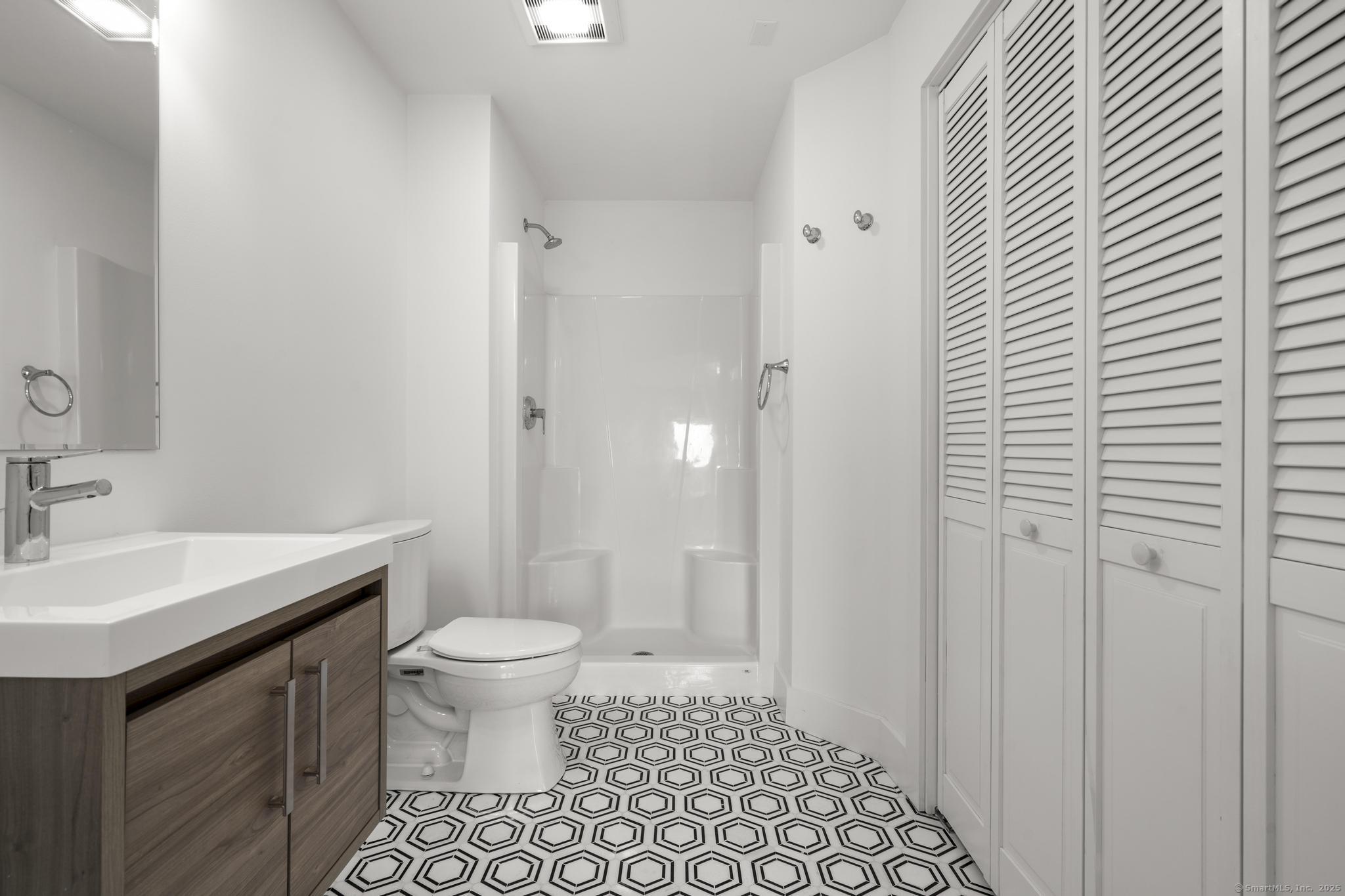 245 East Main Street, Unit 2 Branford, CT 06405 - Photo 39 of 40 a bathroom with a sink a toilet a shower and a mirror