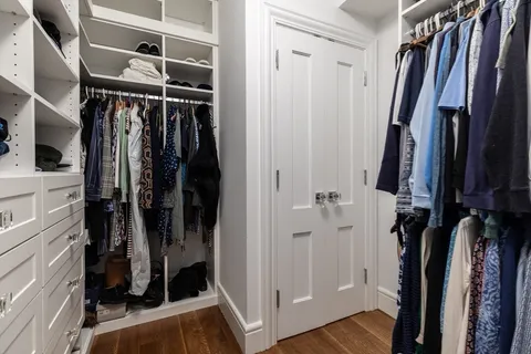 a view of walk in closet with clothes and shoes