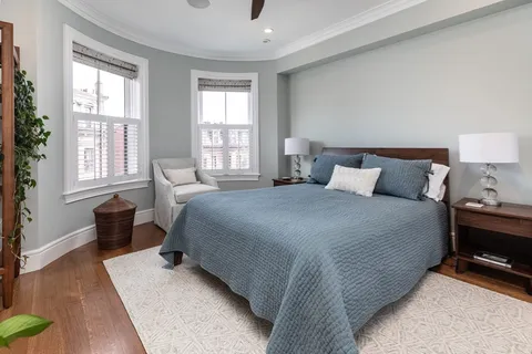 a bedroom with a bed and wooden floor