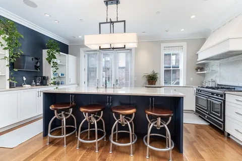 a kitchen with a dining table chairs stainless steel appliances and cabinets