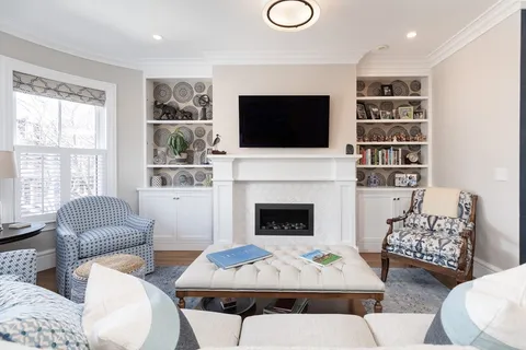 a living room with furniture a flat screen tv and a fireplace