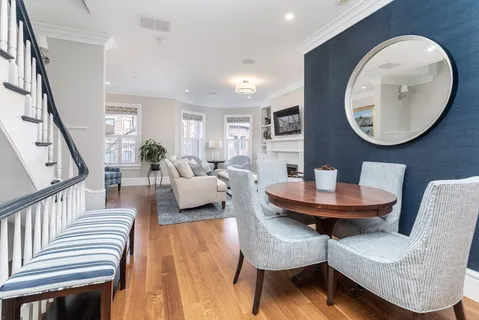 a living room with furniture a mirror and a wooden floor