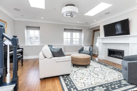 a living room with furniture a flat screen tv and a fireplace