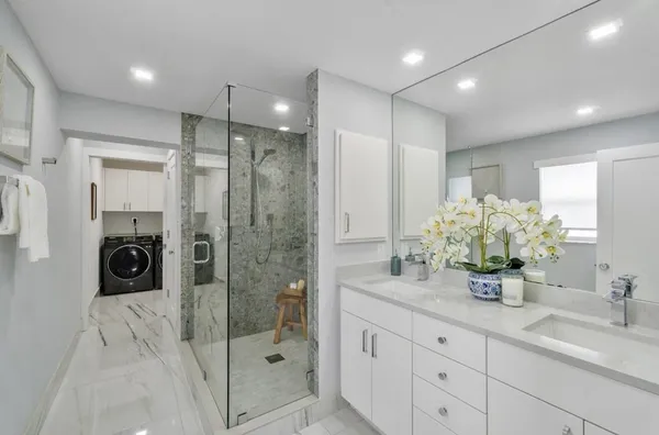 a bathroom with a double vanity sink and shower