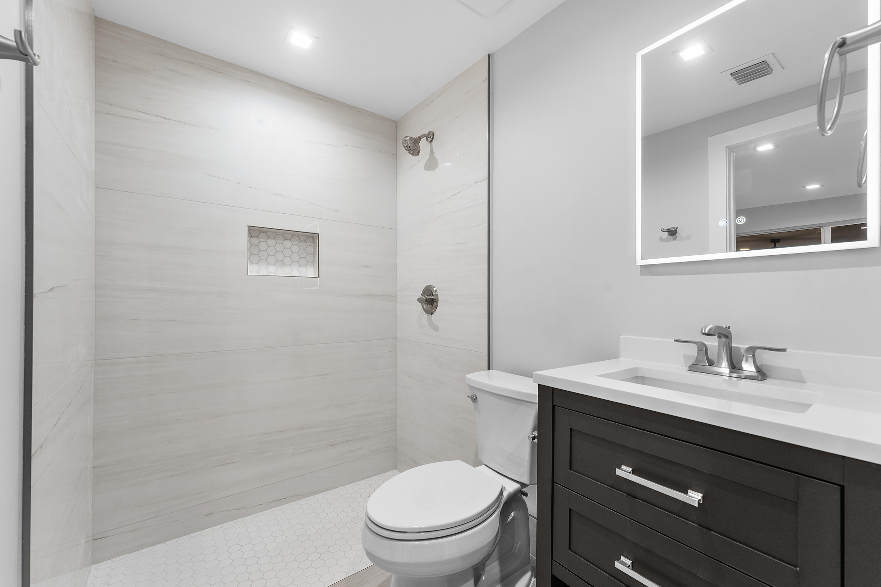 2846 Northeast 35th Court Lighthouse Point, FL 33064 - Photo 18 of 37 a bathroom with a toilet a sink a mirror a vanity and shower