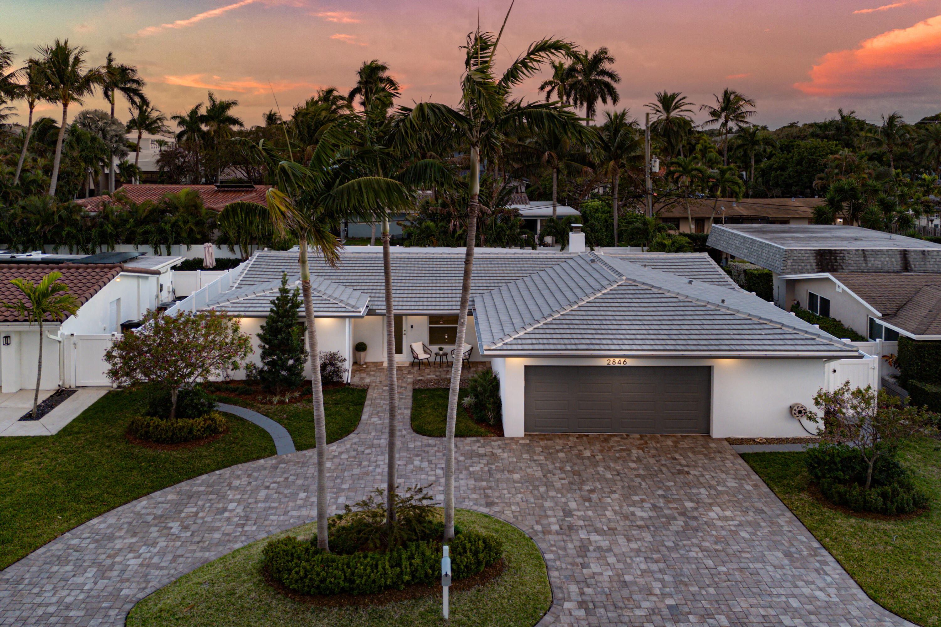 2846 Northeast 35th Court Lighthouse Point, FL 33064 - Photo 2 of 37 a front view of a house with a yard fire pit and outdoor seating
