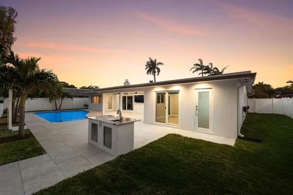 a view of a house with backyard and sitting area