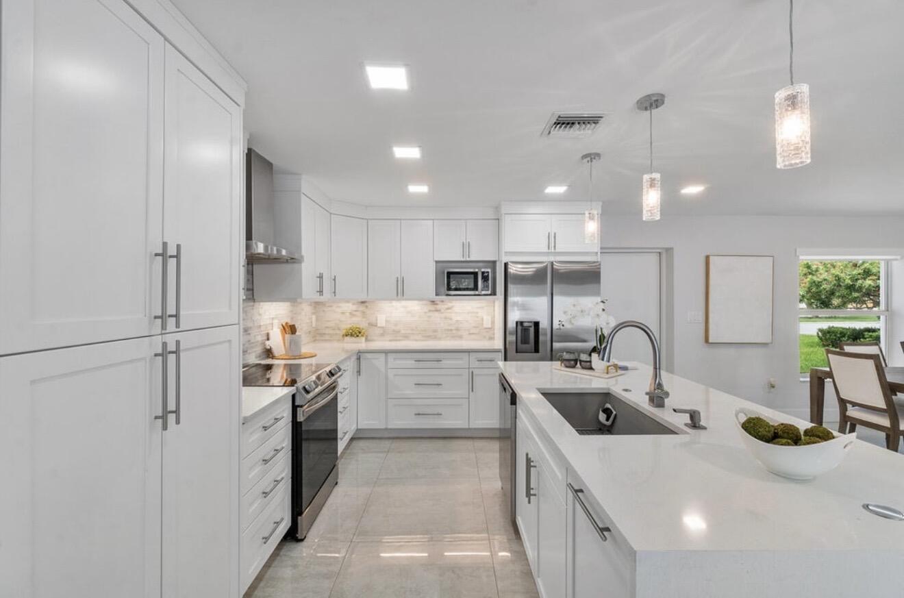 2846 Northeast 35th Court Lighthouse Point, FL 33064 - Photo 8 of 37 a kitchen with white cabinets and sink