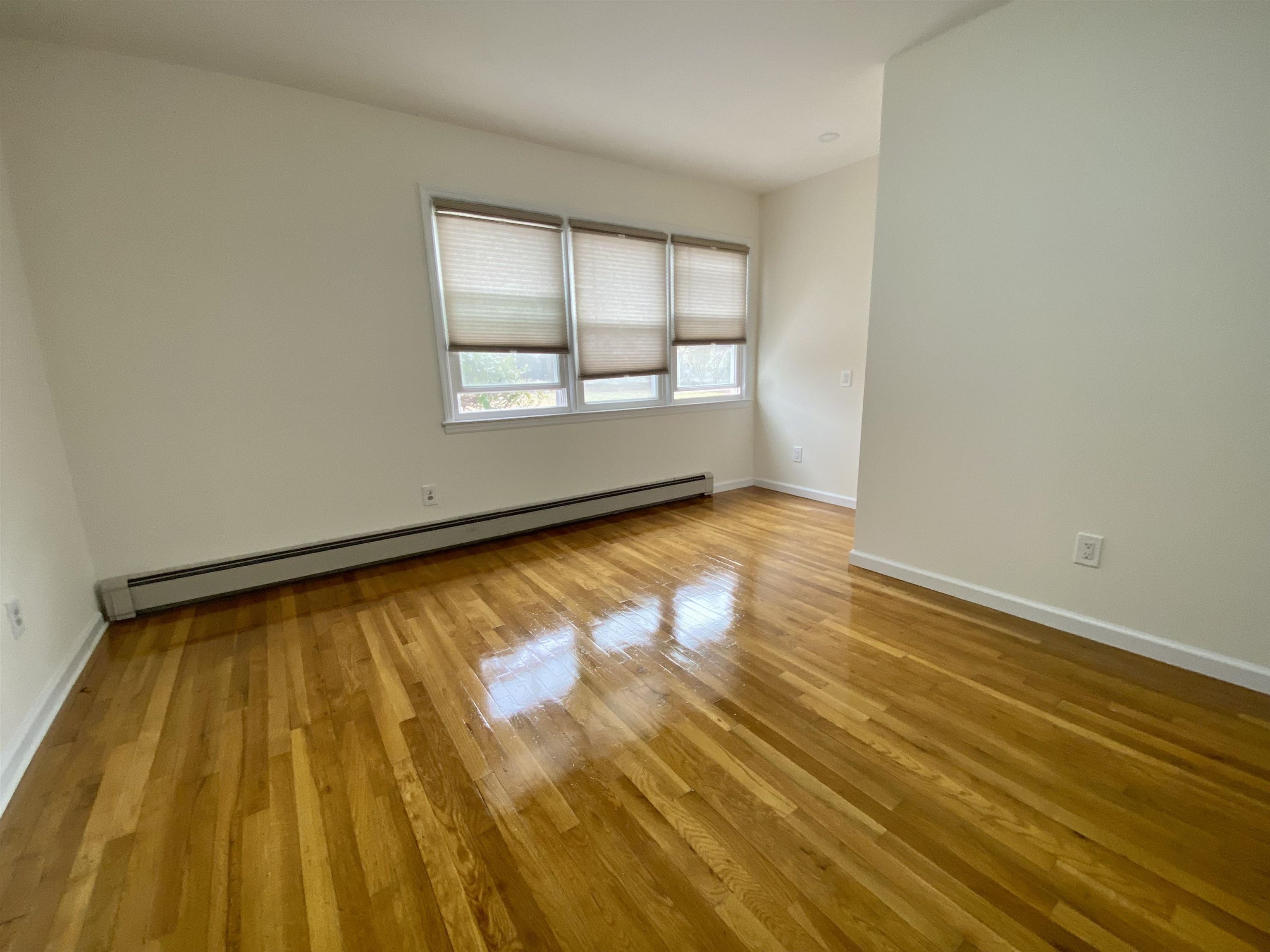 228 Tenafly Road, Unit 1 Tenafly, NJ 07670 - Photo 9 of 10 wooden floor in an empty room with a window