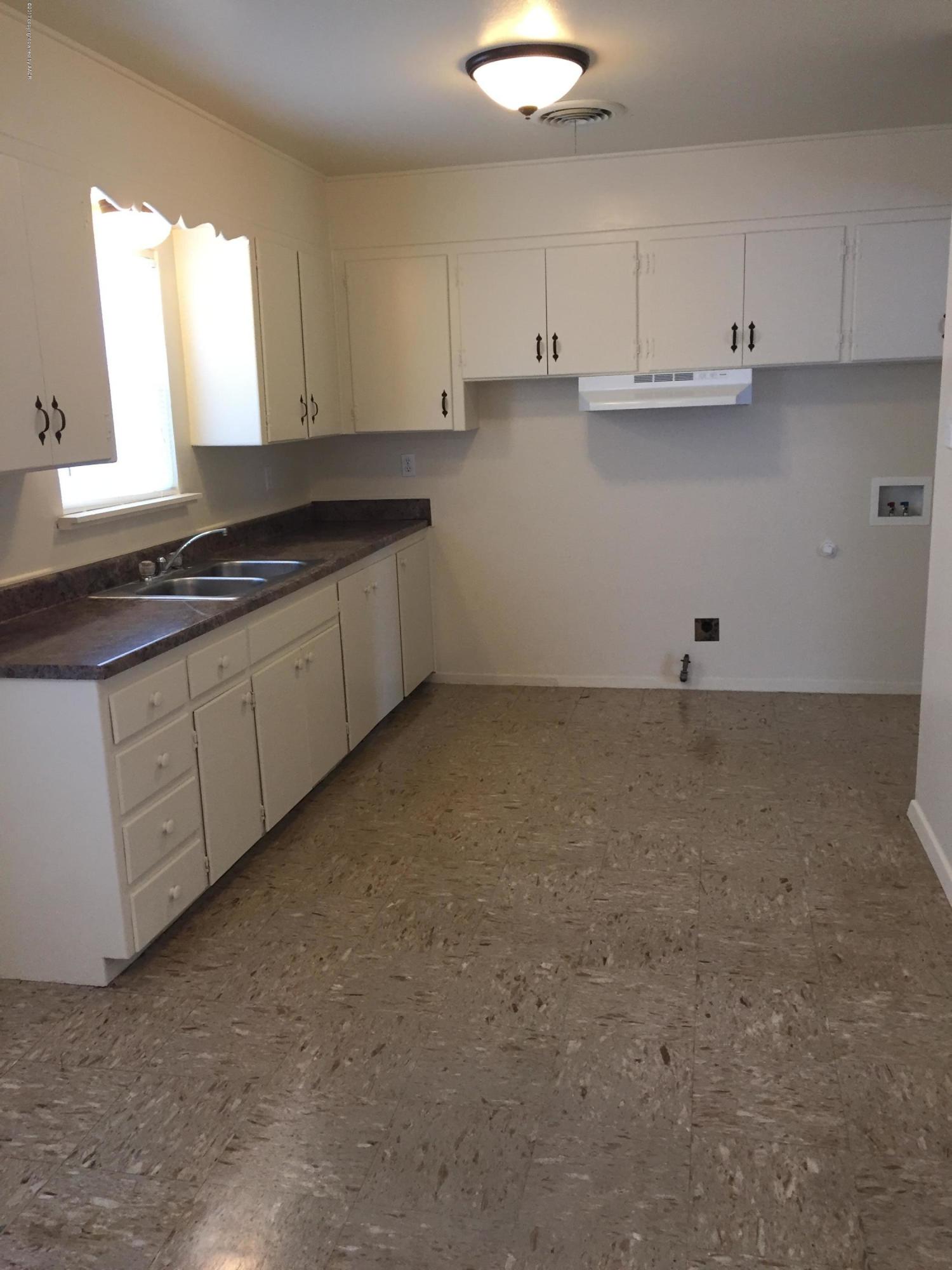 2402 Walnut Street Amarillo, TX 79107 - Photo 8 of 17 a kitchen with granite countertop white cabinets and a sink