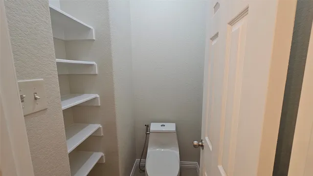 a white toilet sitting next to a white cabinet