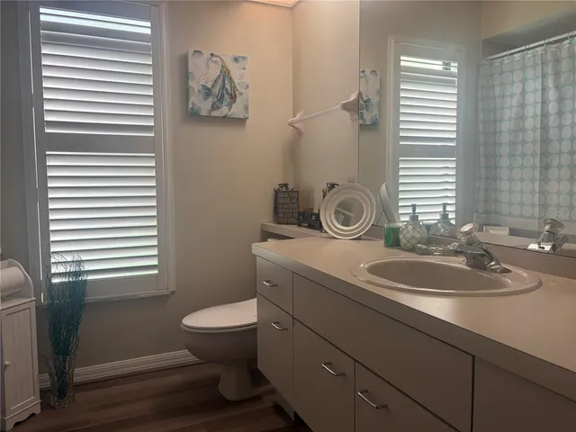 a bathroom with a granite countertop toilet a sink and a mirror
