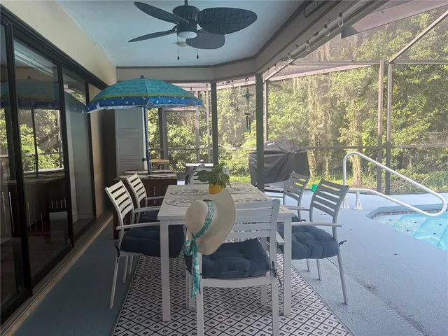 a dining room with furniture large windows and wooden floor