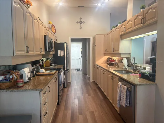 a kitchen with kitchen island granite countertop lots of counter top space and stainless steel appliances