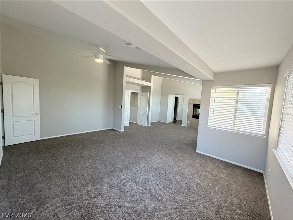 6116 Rabbit Track Street Las Vegas, NV 89130 - Photo 10 of 28 A spacious, naturally illuminated room features plush carpeting and a modern fireplace.