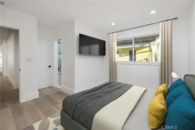 a bedroom with a large bed and a flat screen tv