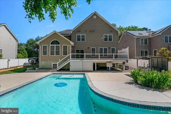 a view of a house with pool and a yard