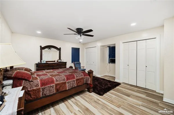 a bedroom with two beds and a ceiling fan