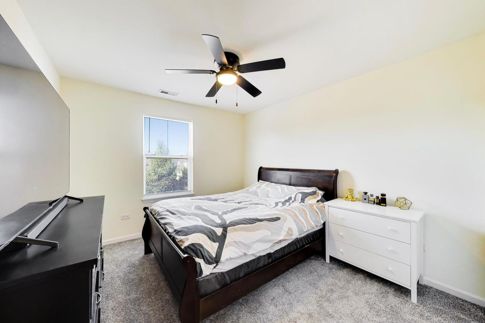 4152 Calder Lane Aurora, IL 60504 - Photo 19 of 30 a bedroom with a bed and a ceiling fan