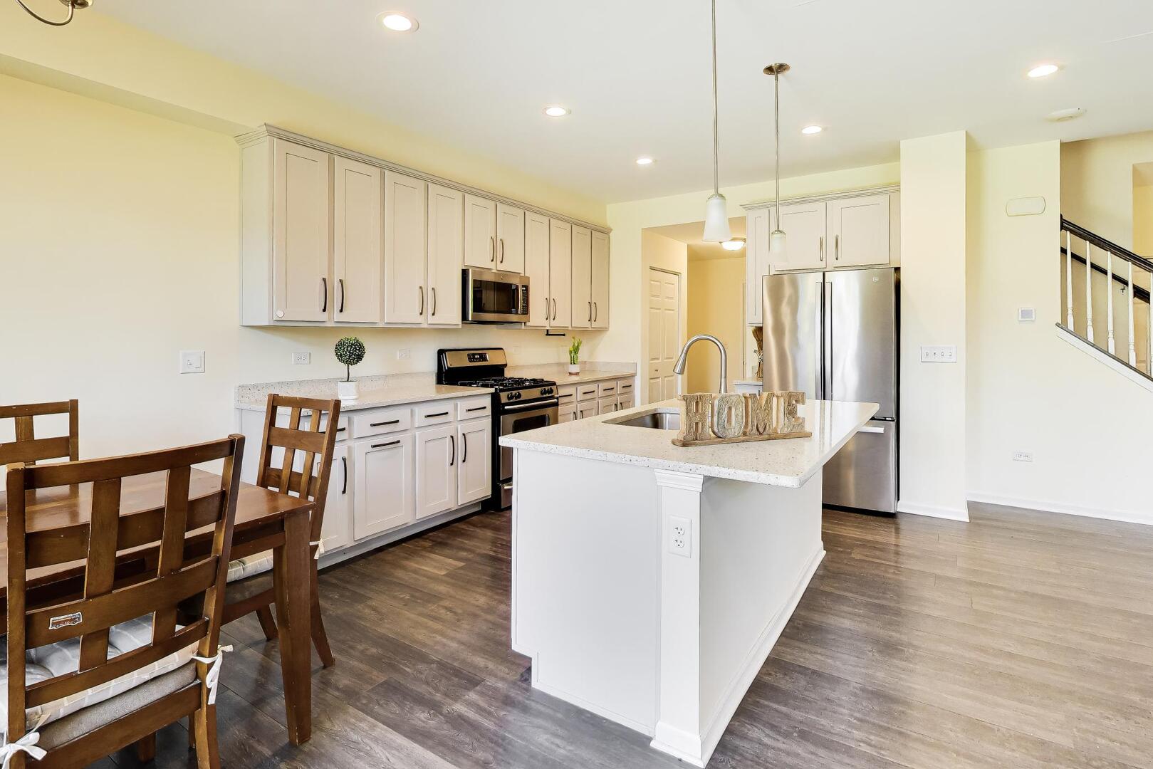 4152 Calder Lane Aurora, IL 60504 - Photo 7 of 30 a kitchen with kitchen island granite countertop a sink a counter top space stainless steel appliances and cabinets