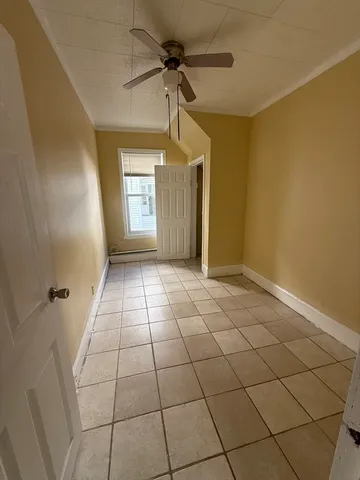 a view of a livingroom with a chandelier fan and windows