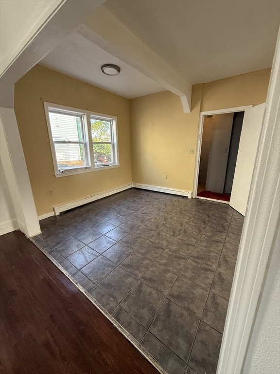 213 Concord Street, Unit 1 Lowell, MA 01852 - Photo 5 of 12 an empty room with wooden floor and windows
