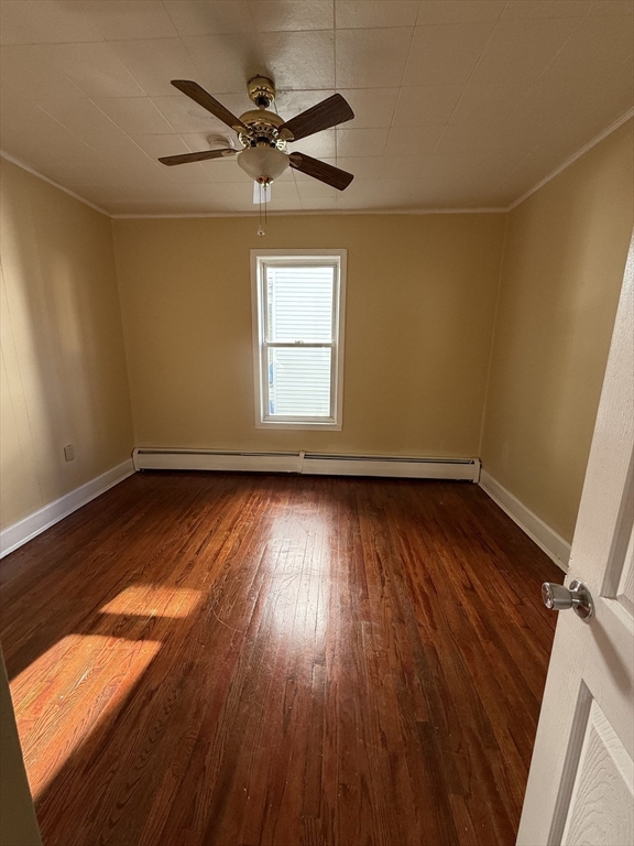 213 Concord Street, Unit 1 Lowell, MA 01852 - Photo 7 of 12 an empty room with wooden floor fan and windows