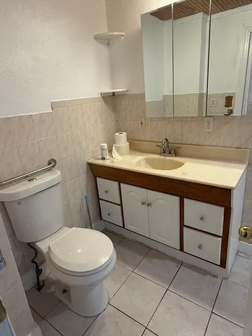 a bathroom with a toilet sink and mirror