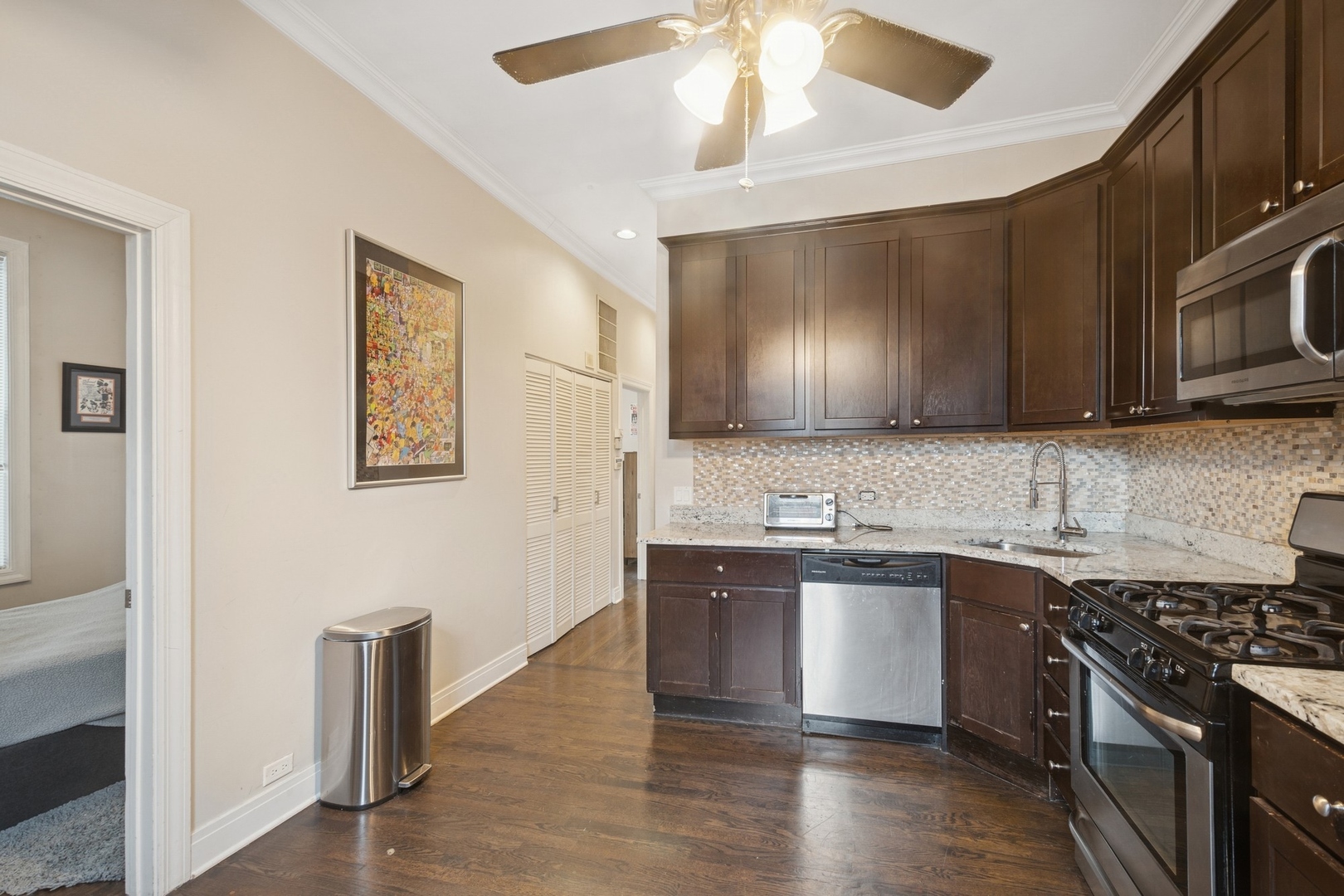 1302 North Cleveland Avenue, Unit 2 Chicago, IL 60610 - Photo 5 of 12 a kitchen with stainless steel appliances granite countertop a sink stove and microwave