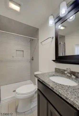 a bathroom with a granite countertop sink a toilet and a mirror