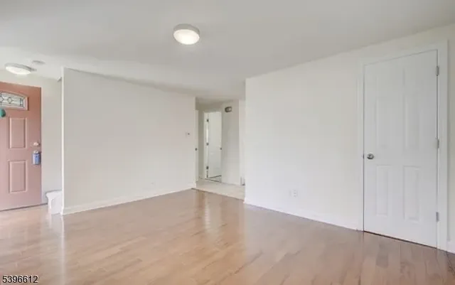 a view of an empty room with wooden floor