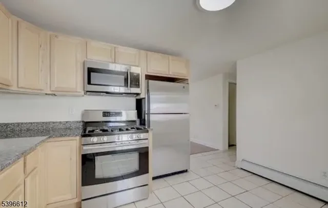 a kitchen with granite countertop white cabinets and stainless steel appliances