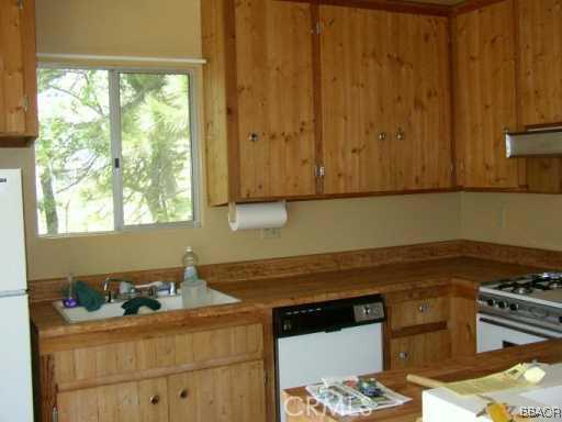 26600 Valley View Lake Rimforest, CA 92378 - Photo 3 of 5 a kitchen with granite countertop cabinets stainless steel appliances and a window
