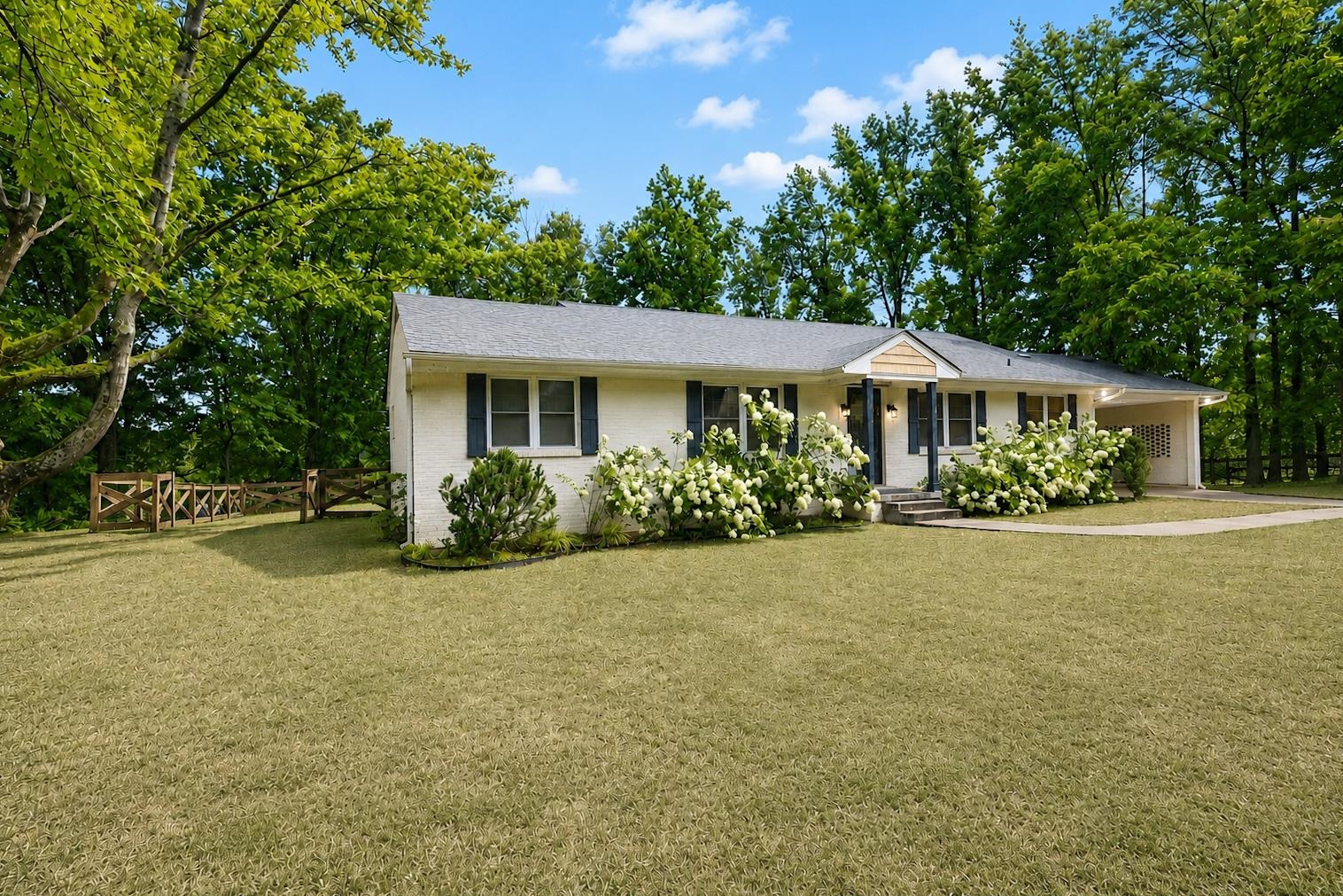 10093 Mt Carmel Road Brighton, TN 38011 - Photo 2 of 36 Ranch-style exterior with white brick and dark shutters, featuring a covered front entry with columns