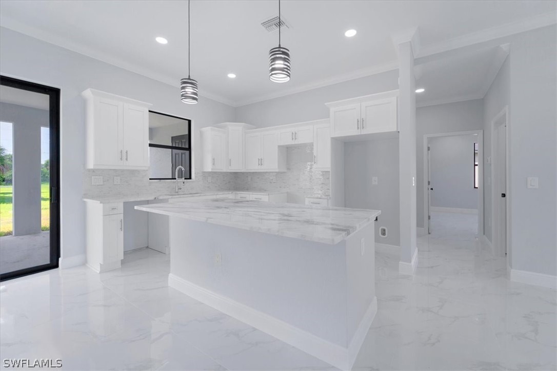 3915 20th Street Southwest Lehigh Acres, FL 33976 - Photo 13 of 50 a large kitchen with kitchen island a sink stainless steel appliances and cabinets