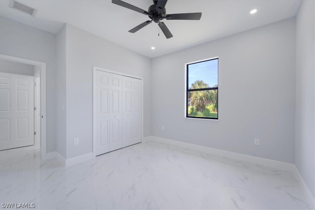 3915 20th Street Southwest Lehigh Acres, FL 33976 - Photo 20 of 50 an empty room with windows and fan