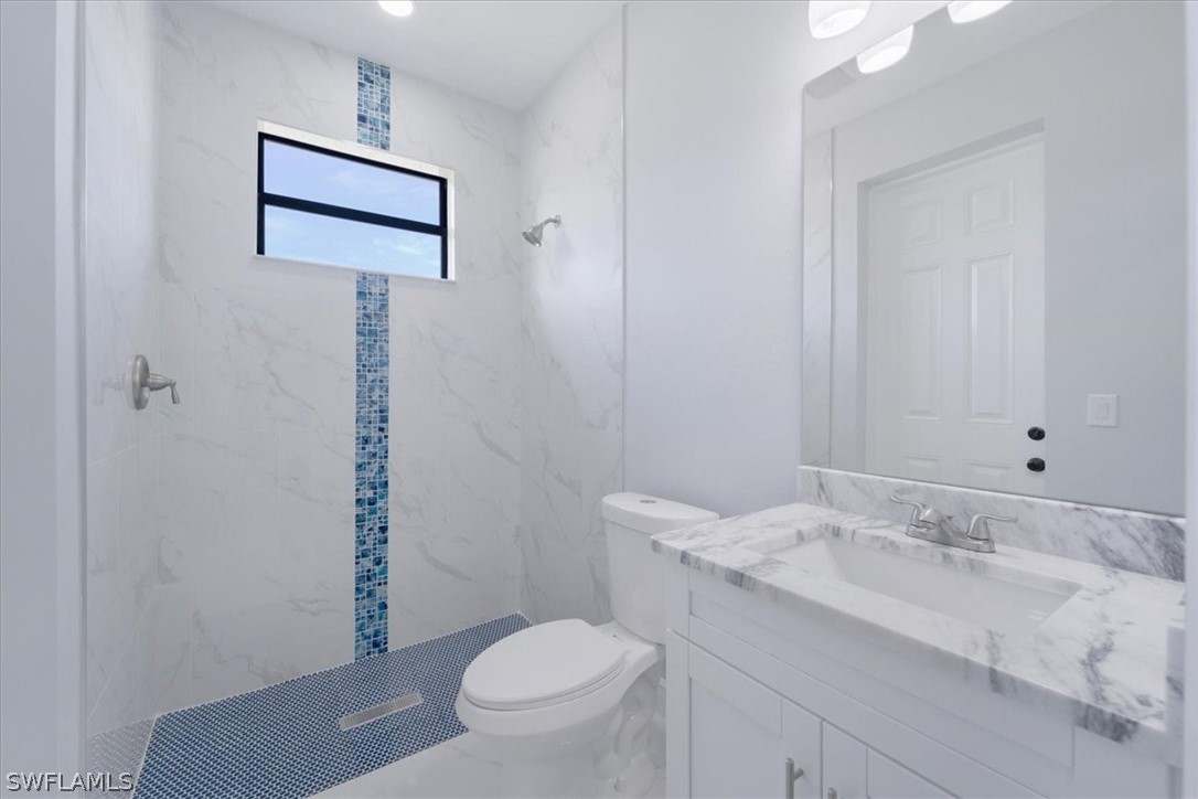 3915 20th Street Southwest Lehigh Acres, FL 33976 - Photo 21 of 50 a bathroom with a granite countertop sink toilet and shower