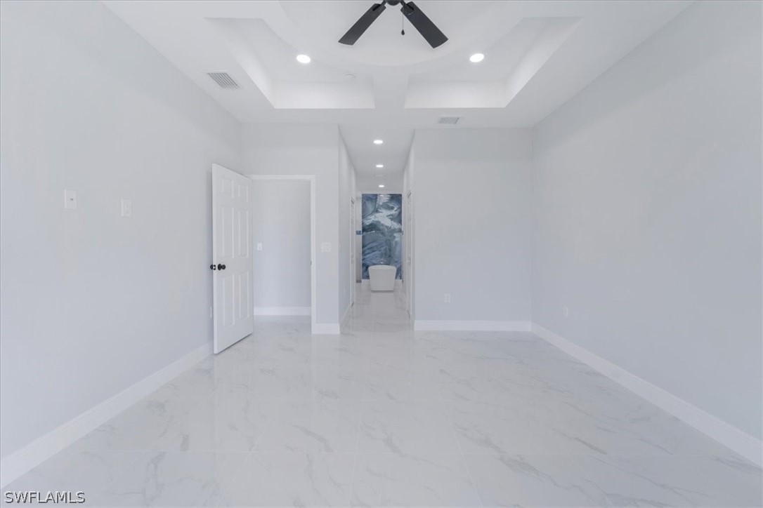 3915 20th Street Southwest Lehigh Acres, FL 33976 - Photo 25 of 50 en empty room with white walls and chandelier fan