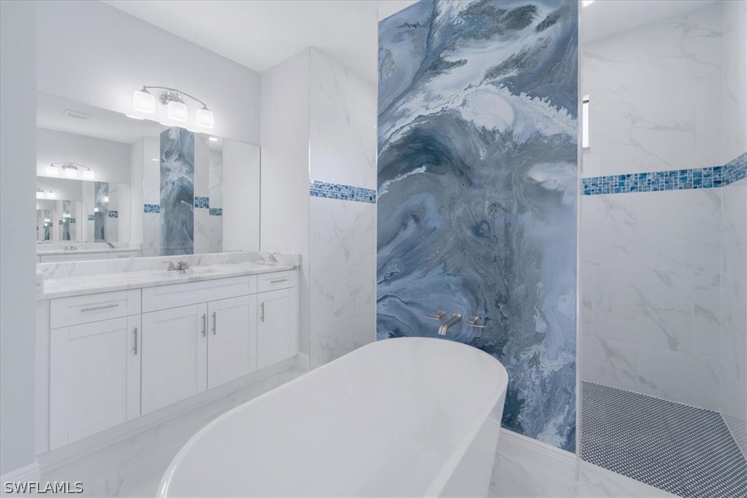 3915 20th Street Southwest Lehigh Acres, FL 33976 - Photo 29 of 50 a bathroom with a granite countertop bathtub sink vanity and toilet