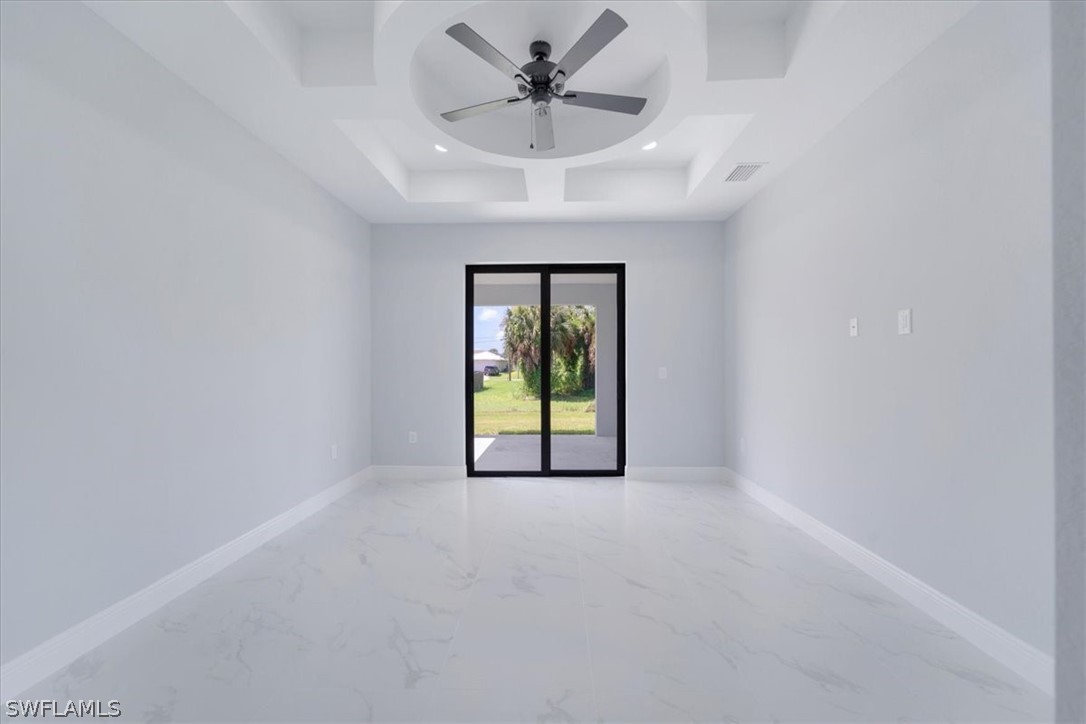 3915 20th Street Southwest Lehigh Acres, FL 33976 - Photo 34 of 50 an empty room with a chandelier fan and windows