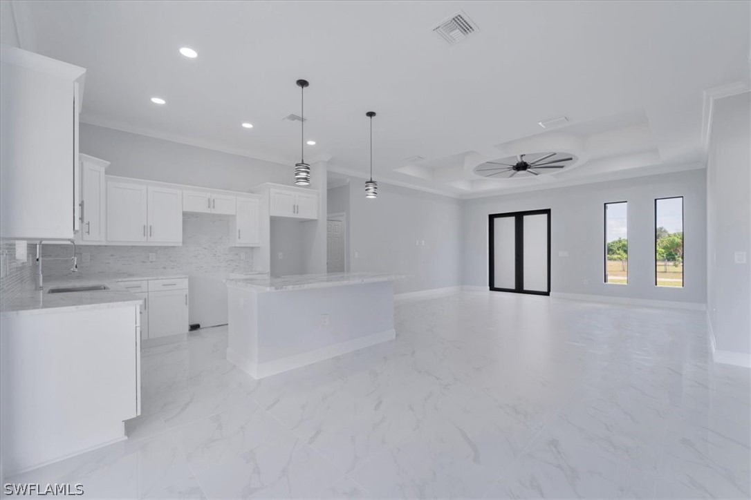 3915 20th Street Southwest Lehigh Acres, FL 33976 - Photo 8 of 50 a large white kitchen with white cabinets and a fireplace