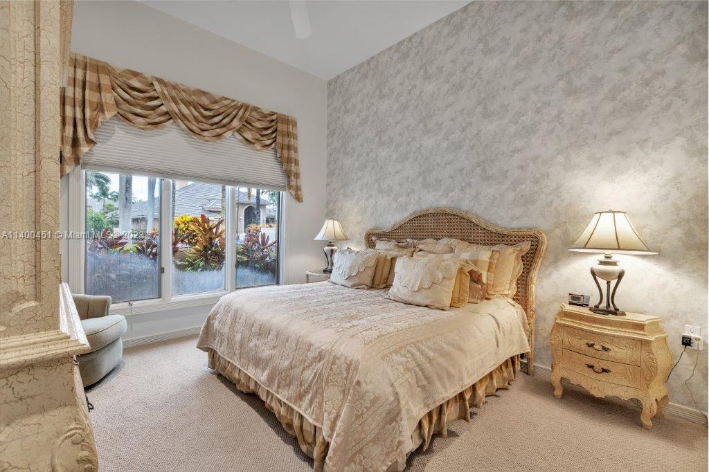 7236 Queenferry Circle Boca Raton, FL 33496 - Photo 17 of 31 a bedroom with a bed a mirror and a lamp on table